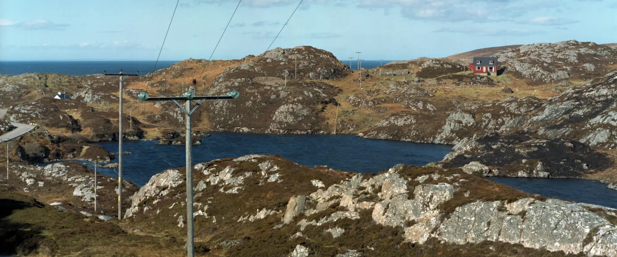Photo of a rocky landscape with water and electricity pylons